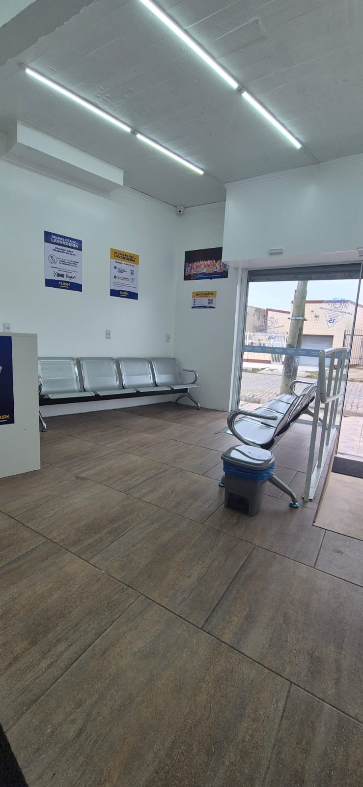 Área de espera com bancos e entrada da lavanderia